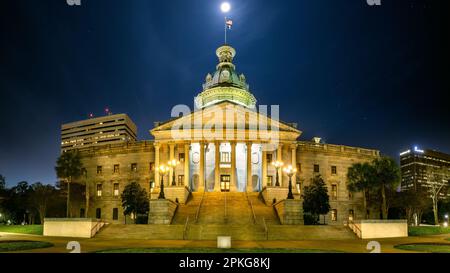 Illuminated South Carolina State House, in Columbia, SC, under a starry sky with a full moon. The South Carolina State House is the building housing t Stock Photo