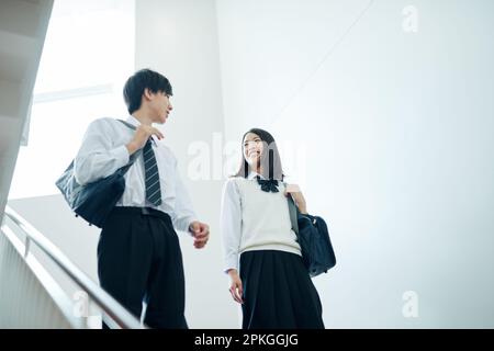 High school students of both sexes talking as they move from one classroom to another Stock Photo