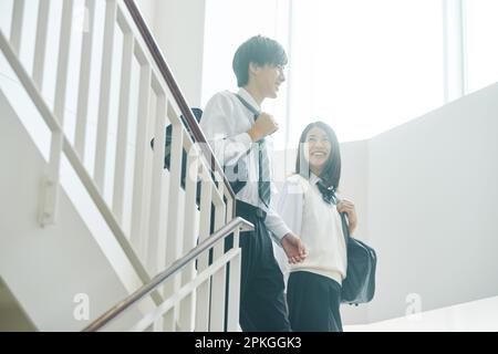 High school students of both sexes talking in a classroom Stock Photo