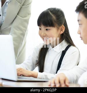 Elementary school students studying programming Stock Photo