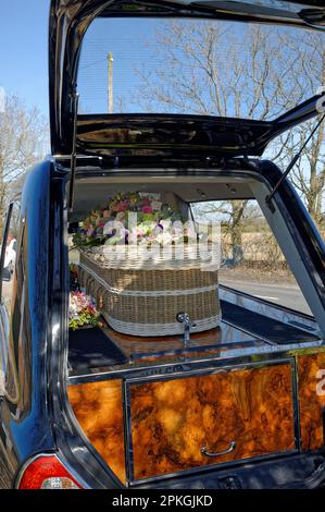 Close up of a wicker cofffin with a wreath in a hearse at a funeral Stock Photo