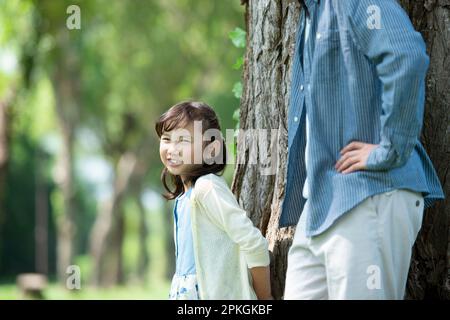 A girl leaning against a tree and smiling Stock Photo