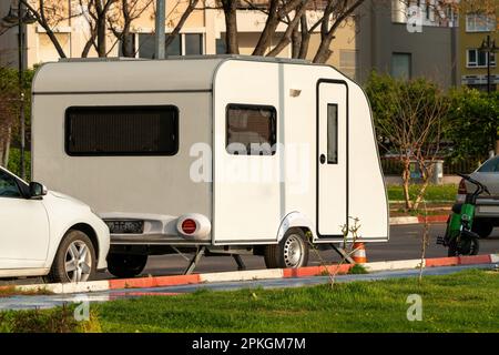 A white caravan spotted on the roadside Stock Photo