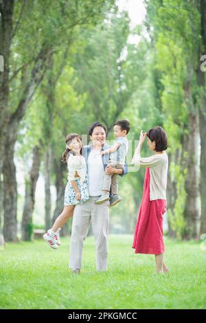Parent and child playing at poplar-lined avenue of trees Stock Photo