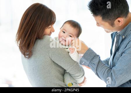 Parents watching over baby Stock Photo