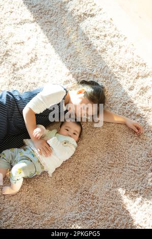 Sisters lying on the carpet Stock Photo