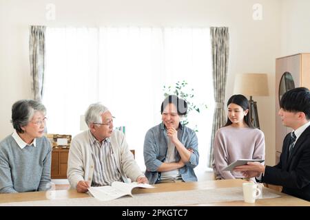 Family of 2 generations talking with a businessman Stock Photo