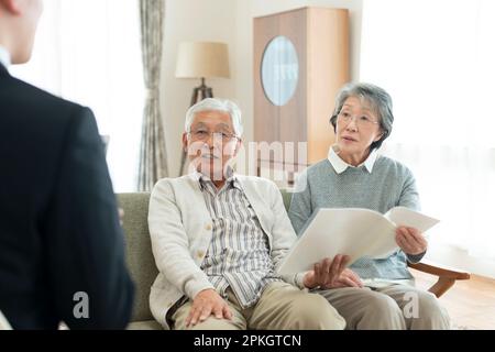 Senior couple talking with businessman Stock Photo