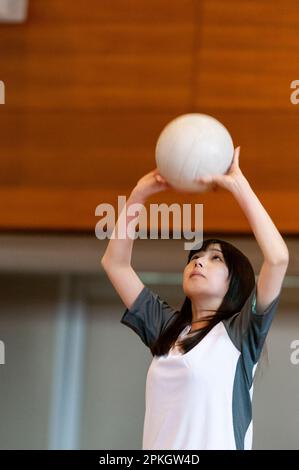 Female students playing volleyball in the gym Stock Photo