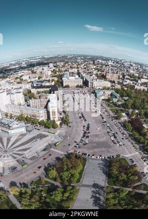 Aerial fisheye panorama view on Freedom (Svobody) Square with green spring park and cars parking. Kharkiv city center, Ukraine Stock Photo