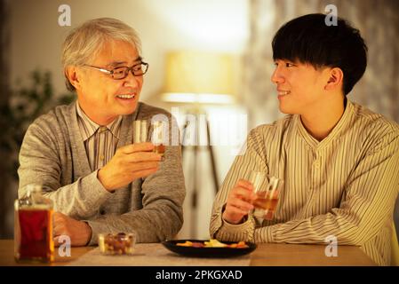 Parents and children toasting with whiskey Stock Photo