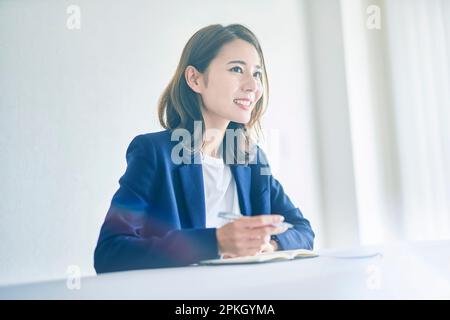 Woman taking notes with a smile Stock Photo