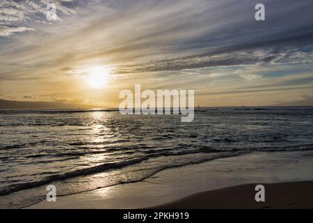 Dramatic sunset over ocean with tide rolling in. Stock Photo