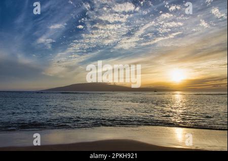 Dramatic sunset over ocean with tide rolling in. Stock Photo