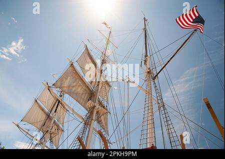 Backlit high-masted sails on tall sailing ship. Stock Photo