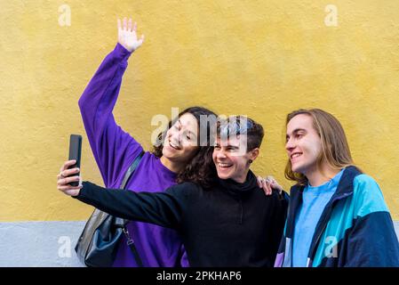 Young diverse friends taking selfies with a mobile phone outdoors. Stock Photo