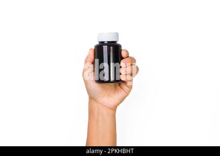 Female hand holding blank pill bottle isolated on white background. Packaging for pill, capsule or supplement with copy space for text. Stock Photo