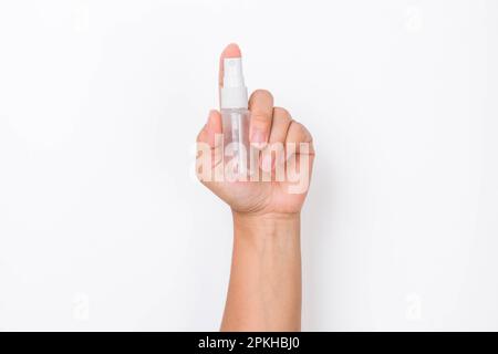Female hand holding cosmetic bottle or Instant antiseptic hand sanitizer mist spray isolated on white background. Stock Photo
