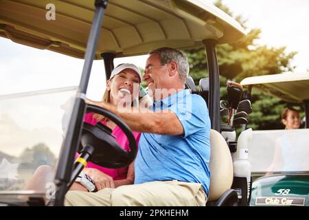 Its the only way to get travel on a golf course. an affectionate mature couple spending a day on the golf course. Stock Photo