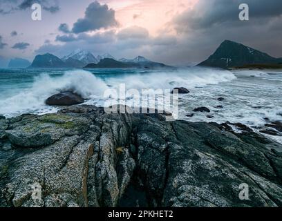 A majestic view of a rocky coastline with waves crashing against the shoreline Stock Photo
