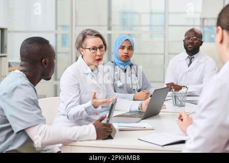 Group of doctors having meeting in office and discussing difficult disease of patient Stock Photo