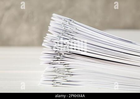 Stack of white paper with clips on grey background. Top view Stock Photo