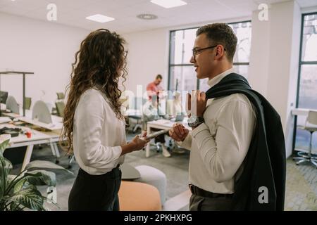 Two business colleagues talking in private and discussing something work related Stock Photo