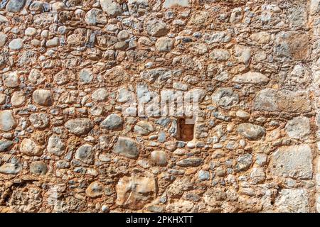 Empty stonewall material with beige cement background texture. Vintage stone wall, blank masonry or floor backdrop, sunny day. Copy space. Stock Photo