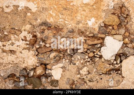 Empty aged stonewall material background texture. Βlank masonry, οld, worn, distressed stone wall structure, plaster and peeled paint layer. Copy spac Stock Photo