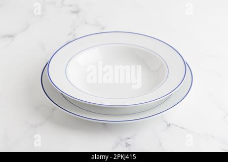 Empty white soup plate with blue stripe on a white background Stock Photo