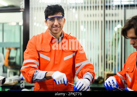 Engineers working and solving problems on machine at industrial plant Stock Photo
