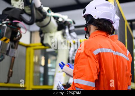 Robotics controller engineers working and solving problems on machine Stock Photo