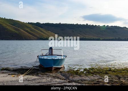 the boat stands on the bank of the river. Means of transportation on water. Stock Photo