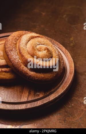 Cinnamon Rolls on a Wooden plate and a rustic table Stock Photo
