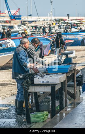 Local fishermen selling on the stalls raw fresh fish, sea fruits or sushi, ready to eat at an open air market in Bari, Puglia, Italy Stock Photo