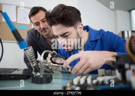 technician fitting component into computer Stock Photo