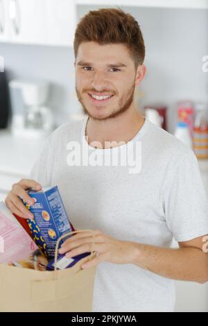 young man bringing groceries home Stock Photo