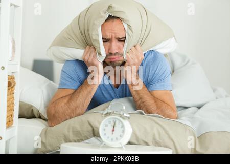 sad and upset man waking up in the morning light Stock Photo