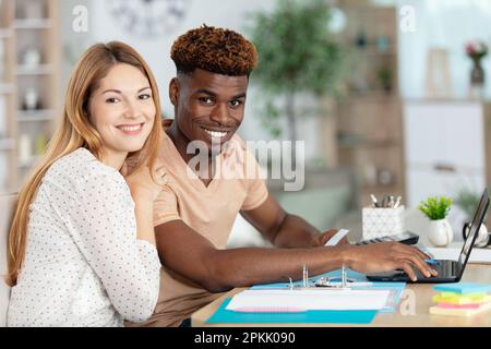 young couple sitting and managing expenses at home Stock Photo