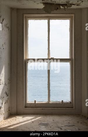 old sash window with a view of the sea in abandoned property Stock Photo