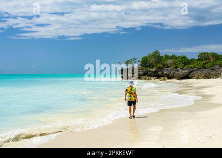 Mid adult man walking on empty sand beach, Nungwi, Zanzibar, Tanzania, East Africa, Africa Stock Photo