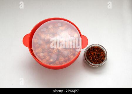 Chili Covered Popcorn Made in Red Microwave Container Stock Photo