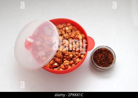 Chili Covered Popcorn Made in Red Microwave Container Stock Photo