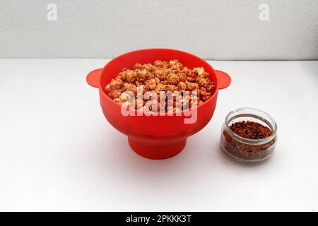 Chili Covered Popcorn Made in Red Microwave Container Stock Photo