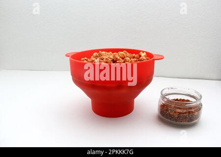 Chili Covered Popcorn Made in Red Microwave Container Stock Photo