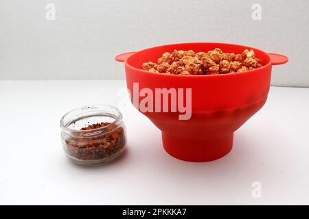 Chili Covered Popcorn Made in Red Microwave Container Stock Photo