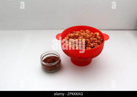 Chili Covered Popcorn Made in Red Microwave Container Stock Photo