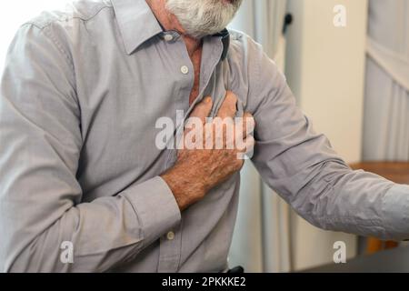 Senior man holding hand on chest and suffering from heart problem Stock Photo