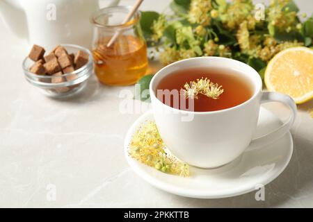 Cup of tea with linden blossom on light grey marble table Stock Photo
