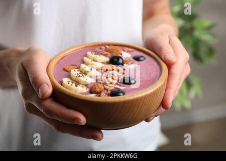 Woman holding dessert bowl with delicious acai smoothie, closeup view Stock Photo